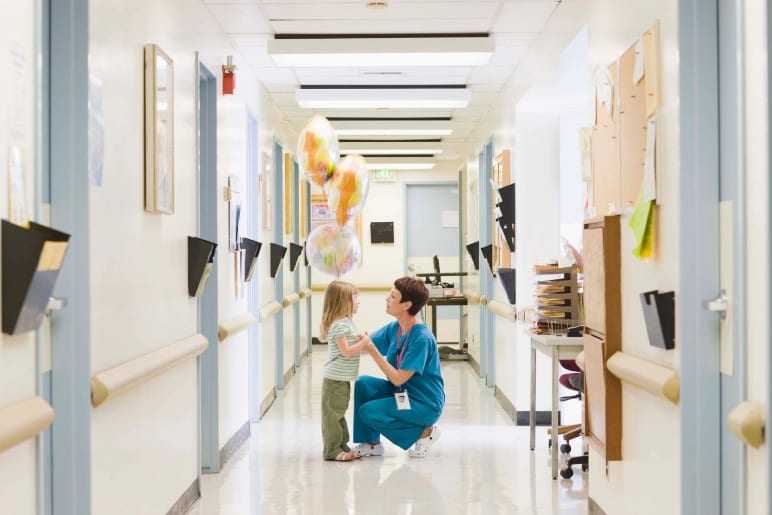 Health care worker greeting a child.