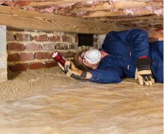 PURCOR Pest Solutions agent performing a home inspection in crawl space under home.